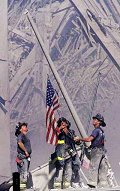 firefighters hanging the flag in the rubble